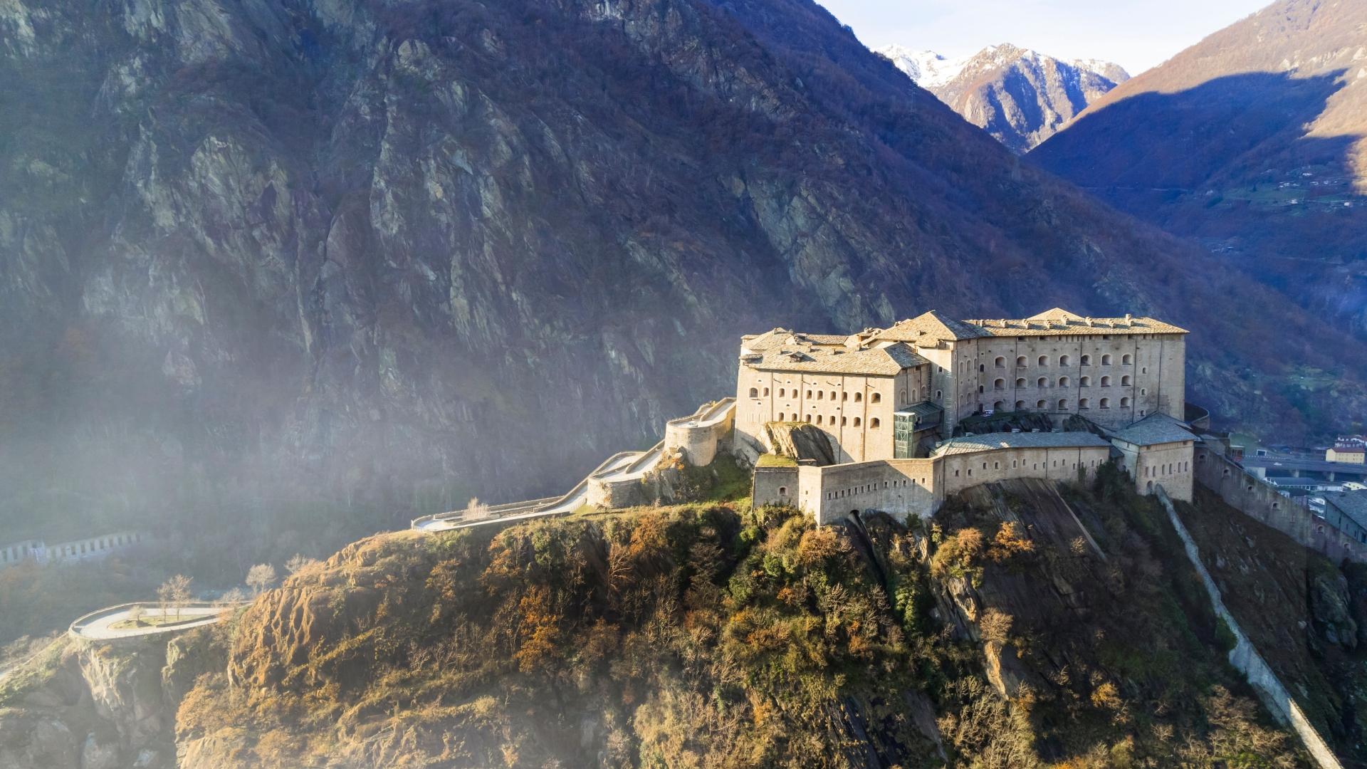 Imponente fortezza su una collina circondata da montagne.