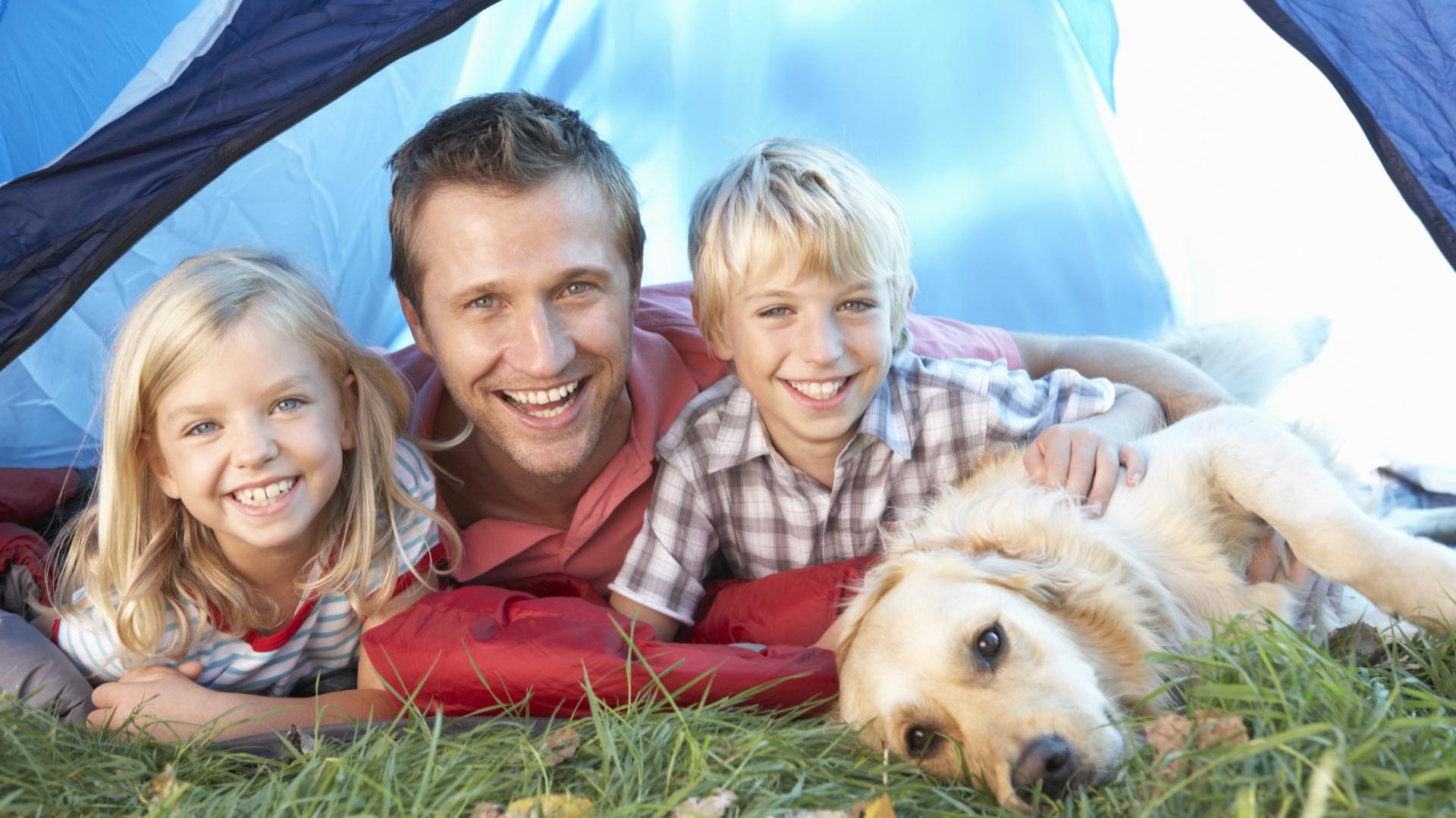 Famiglia felice in campeggio con il loro cane.