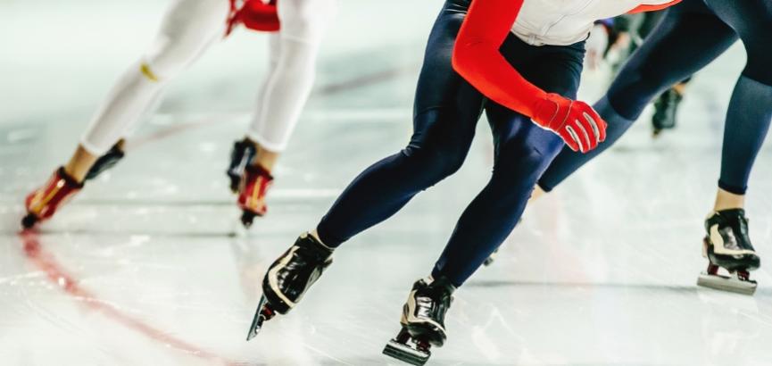 Pattinatori di velocità in azione su una pista di ghiaccio.