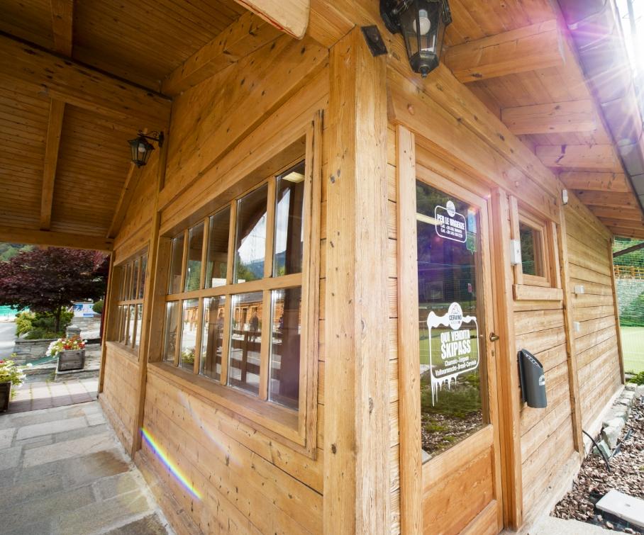 Chalet di legno con vendita skipass, vicino a un campo sportivo.