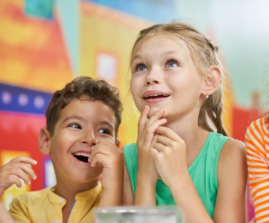 Bambini felici e curiosi in una classe colorata.